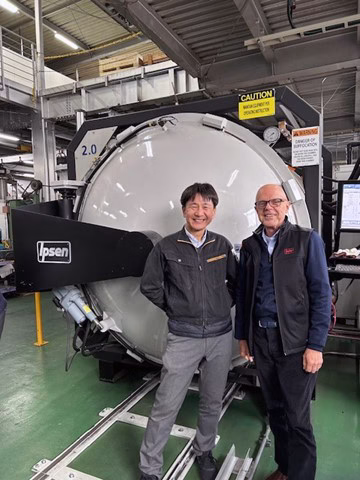 Representatives from Finetech and Ipsen stand in front of an Ipsen TITAN vacuum furnace.